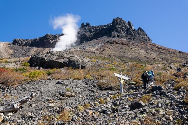 那須岳から噴煙が登っている風景。最新の火山噴火警戒レベル確認が必要なことを説明。